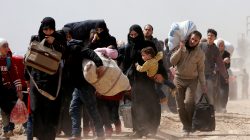 FILE PHOTO: People walk with their belongings as they flee the rebel-held town of Hammouriyeh, in the village of Beit Sawa, eastern Ghouta, Syria March 15, 2018. REUTERS/Omar Sanadiki