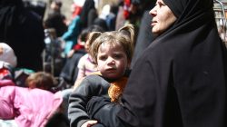 A woman holds a child during evacuation from the besieged town of Douma, Eastern Ghouta, in Damascus, Syria March 22, 2018. REUTERS/Bassam Khabieh