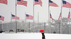 A woman holds an umbrella as she walks toward the Washington Monument during a snowstorm in Washington, U.S., March 21, 2018. REUTERS/Kevin Lamarque