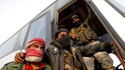 FILE PHOTO: Rebel fighters gesture as they stand next to a bus before their evacuation, at Harasta highway outside Jobar, in Damascus, Syria March 26, 2018. REUTERS/Omar Sanadiki/File Photo