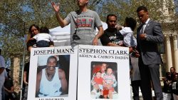 Salena Manni (L), fiancee of Stephon Clark, holds their son Cairo and an unidentified man holds son Aiden (2nd R) while Basim Elkarra speaks and Rev Shane Harris listens at a rally in Sacramento, California, U.S., March 31, 2018. REUTERS/Bob Strong