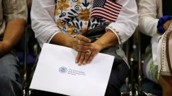 FILE PHOTO: An attendee holds her new country's flag and her naturalization papers as she is sworn in during a U.S. citizenship ceremony in Los Angeles, U.S., July 18, 2017. REUTERS/Mike Blake/File Photo