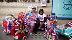 A supporter of the royal family holds a doll wearing a crown as he sits outside the Lindo Wing of St Mary's Hospital after Britain's Catherine, the Duchess of Cambridge, was admitted after going into labour ahead of the birth of her third child, in London, April 23, 2018. REUTERS/Henry Nicholls