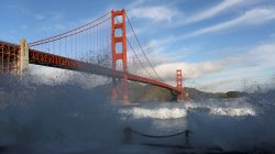 FILE PHOTO: Waves crash against a sea wall in San Francisco Bay beneath the Golden Gate Bridge in San Francisco, California, December 16, 2014. REUTERS/Robert Galbraith//File Photo