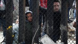 A group of members of a migrant caravan from Central America and their supporters look through the U.S.-Mexico border wall at Border Field State Park before making an asylum request in San Diego, California, April 29, 2018. REUTERS/Lucy Nicholson