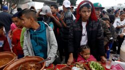 Members of a caravan of migrants from Central America line up to receive food near the San Ysidro checkpoint as the first fellow migrants entered U.S. territory to seek asylum on Monday, in Tijuana, Mexico April 30, 2018. REUTERS/Edgard Garrido
