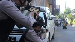 Police aim their weapons at a man who was being searched by other police officers following an explosion at nearby police headquarters in Surabaya, Indonesia May 14, 2018 in this photo taken by Antara Foto. Antara Foto/ Didik Suhartono / via REUTERS