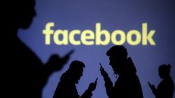 FILE PHOTO: Silhouettes of mobile users are seen next to a screen projection of Facebook logo in this picture illustration taken March 28, 2018. REUTERS/Dado Ruvic/Illustration/File Photo