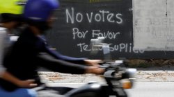 A motorcycle passes graffiti painted on a fence in Caracas, Venezuela May 12, 2018. Graffiti reads: "Do not vote, please I beg you". Picture taken on May 12, 2018. REUTERS/Carlos Jasso
