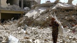 A woman gestures as she stands on rubble of damaged buildings in Raqqa, Syria May 14, 2018. REUTERS/Aboud Hamam