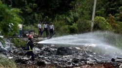 Firefighters work in the wreckage of a Boeing 737 plane that crashed in the agricultural area of Boyeros, around 20 km (12 miles) south of Havana, shortly after taking off from Havana's main airport in Cuba, May 18, 2018. REUTERS/Alexandre Meneghini