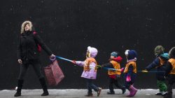 A schoolteacher, who wished to stay unidentified, attempts to catch snowflakes while leading her students to a library from school in the Harlem neighborhood, located in the Manhattan borough of New York on January 10, 2014. REUTERS/Adrees Latif