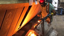 A worker pours molten iron into molds to form parts for Caterpillar Inc. and other industrial customers at Kirsh Foundry Inc. in Beaver Dam, Wisconsin, U.S., April 12, 2018. REUTERS/Timothy Aeppel