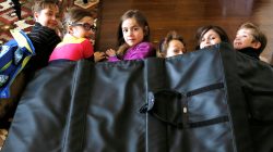 FILE PHOTO: Children demonstrate how they might take shelter in a school under a bulletproof blanket sold by Elite Sterling Security LLC (ESS) in Aurora, Colorado March 19, 2013. REUTERS/Rick Wilking/File Photo