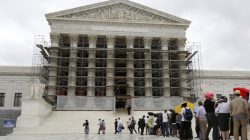 Visitors to the Supreme Court are pictured in the rain in Washington, October 7, 2013. The U.S. Supreme Court will this week step into the politically charged debate over campaign finance for the first time since its controversial ruling three years ago paved the way for corporations and unions to spend more on political candidates and causes. REUTERS/Jason Reed (UNITED STATES - Tags: POLITICS CRIME LAW) - GM1E9A71U4B01