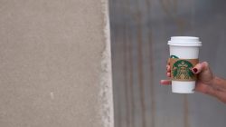A woman walks through Center City clutching a hot Starbucks beverage, before more than 8,000 stores nationwide will close this afternoon for anti-bias training, in Philadelphia, Pennsylvania U.S., May 29, 2018. REUTERS/Mark Makela