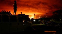 Darryl Sumiki, 52, of Hilo, watches as lava lights up the sky above Pahoa during ongoing eruptions of the Kilauea Volcano in Hawaii, U.S., June 2, 2018. REUTERS/Terray Sylvester