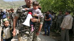 Lebanese general security member holds Syrian refugee children, who fled to Lebanon, as they wait for buses to go back to Syria from the southern village of Shebaa, Lebanon April 18, 2018. REUTERS/Aziz Taher