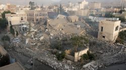 People walk past a building one day after air strikes destroyed it in Sanaa, Yemen June 6, 2018. REUTERS/Khaled Abdullah
