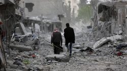 Men walk through debris in the center of Afrin, Syria March 24, 2018. REUTERS/Khalil Ashawi
