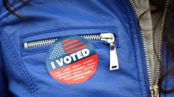 FILE PHOTO: A woman wears a sticker in multiple languages after voting in the primary election at a polling station in Venice, Los Angeles, California, U.S. June 5, 2018. REUTERS/Lucy Nicholson/File Photo