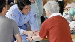 Japan's Prime Minister Shinzo Abe meets local residents staying at an evacuation center in Kurashiki, Okayama Prefecture, Japan, in this photo taken by Kyodo July 11, 2018. Mandatory credit Kyodo/via REUTERS