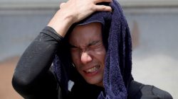 FILE PHOTO: A volunteer, for recovery work, wipes his sweat as he takes a break in a heat wave at a flood affected area in Kurashiki, Okayama Prefecture, Japan, July 14, 2018. REUTERS/Issei Kato/File Photo