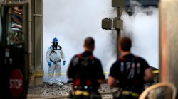 New York Fire Department watch as an emergency responder examines the scene near a steam pipe explosion in Midtown Manhattan, New York City, U.S., July 19, 2018. REUTERS/Brendan McDermid