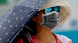 A woman uses a parasol on the street during a heatwave in Tokyo, Japan July 25, 2018. REUTERS/Kim Kyung-Hoon