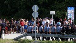 FILE PHOTO: Migrants and Bosnian police eye one another in Velika Kladusa, Bosnia, near the border with Croatia, June 18, 2018. REUTERS/Antonio Bronic/File Photo