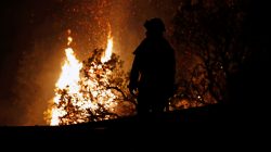 A firefighter watches flames advance up a hill towards homes as crews battle the Carr Fire, west of Redding, California, U.S. July 27, 2018. REUTERS/Fred Greaves