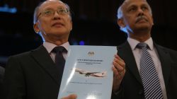 MH370 safety investigator-in-charge Kok Soo Chon shows the MH370 safety investigation report booklet to the media after a news conference in Putrajaya, Malaysia July 30, 2018. REUTERS/Sadiq Asyra