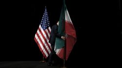 A staff member removes the Iranian flag from the stage after a group picture with foreign ministers and representatives of the U.S., Iran, China, Russia, Britain, Germany, France and the European Union during the Iran nuclear talks at the Vienna International Center in Vienna, Austria July 14, 2015. To match Analysis USA-ELECTION/IRAN