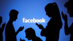 FILE PHOTO: People are silhouetted as they pose with mobile devices in front of a screen projected with a Facebook logo, in this picture illustration taken in Zenica, October 29, 2014. REUTERS/Dado Ruvic/File Photo