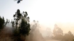 A helicopter drops water on a fire near small village of Monchique, Portugal August 6, 2018. REUTERS/Rafael Marchante