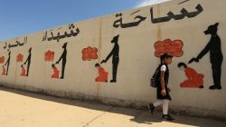 FILE PHOTO: An Iraqi student walks past a school wall covered with drawings showing how Islamic State militants executed their prisoners in Mosul, Iraq April 30, 2018. REUTERS/Ari Jalal/File Photo