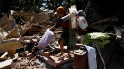A woman carries valuable goods from the ruins of her house at Kayangan district after earthquake hit on Sunday in North Lombok, Indonesia, August 7, 2018. REUTERS/Beawihar