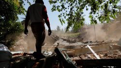 A villager stands near collapsed house at Kayangan district after earthquake hit on Sunday in North Lombok, Indonesia, August 7, 2018. REUTERS/Beawiharta