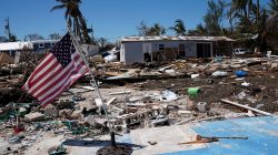 FILE PHOTO: A U.S. flag flies over a debris field of former houses following Hurricane Irma in Islamorada, Florida, U.S., September 15, 2017. REUTERS/Carlo Allegri/File Photo