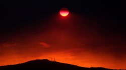 The sun sets under a cloud of smoke caused by a wildfire fanned by strong winds on the island of Evia, in Athens, Greece, August 12, 2018. REUTERS/Yannis Behrakis