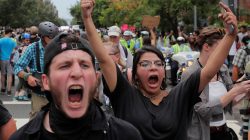 Counter-protesters march in front of white nationalists being escorted by police to a rally, marking the one year anniversary of the 2017 Charlottesville "Unite the Right" protests, in Washington, D.C. August 12, 2018. REUTERS/Lucas Jackson