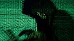 A man holds a laptop computer as cyber code is projected on him in this illustration picture taken on May 13, 2017. REUTERS/Kacper Pempel/Illustration