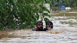 A man rescues a drowning man from a flooded area after the opening of Idamalayr, Cheruthoni and Mullaperiyar dam shutters following heavy rains, on the outskirts of Kochi, India August 16, 2018. REUTERS/Sivaram V