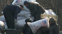 FILE PHOTO - Workers unload food aid from a truck in the Sinuiju region of North Korea in this picture taken on December 11, 2008 from a tourist boat on the Yalu River, which divides North Korea and China. REUTERS/Stringer/File Photo
