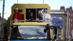A boy gestures as he rides on a truck with wax work figures of Pope Francis and former Pope John Paul II in Dublin, Ireland August 23, 2018. REUTERS/Hannah McKay