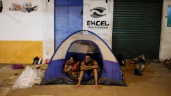 Venezuelan people sit on their tent and sleep on cardboards during the night at the entrance of packages transport shop in front of the interstate Bus Station in Boa Vista, Roraima state, Brazil August 25, 2018. Picture taken August 25, 2018. REUTERS/Nacho Doce