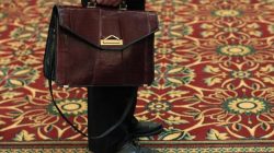 A man holds his briefcase while waiting in line during a job fair in Melville, New York July 19, 2012. REUTERS/Shannon Stapleton