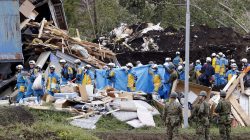 Police officers and members of the Japan Self-Defense Forces (JSDF) carry a missing person found from an area damaged by a landslide caused by an earthquake in Atsuma town, Hokkaido, northern Japan, in this photo taken by Kyodo September 8, 2018. Mandatory credit Kyodo/via REUTERS