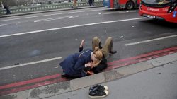 FILE PHOTO: A woman assists an injured person after an incident on Westminster Bridge in London, Britain, March 22, 2017. REUTERS/Toby Melville/File photo