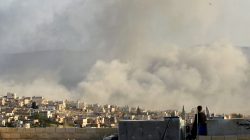 FILE PHOTO: A man watches as smoke rises after what activists said was an air strike on Atimah, Idlib province March 8, 2015. REUTERS/Ammar Abdullah/File Photo